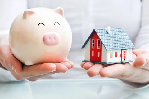 An image of a piggy bank and a house